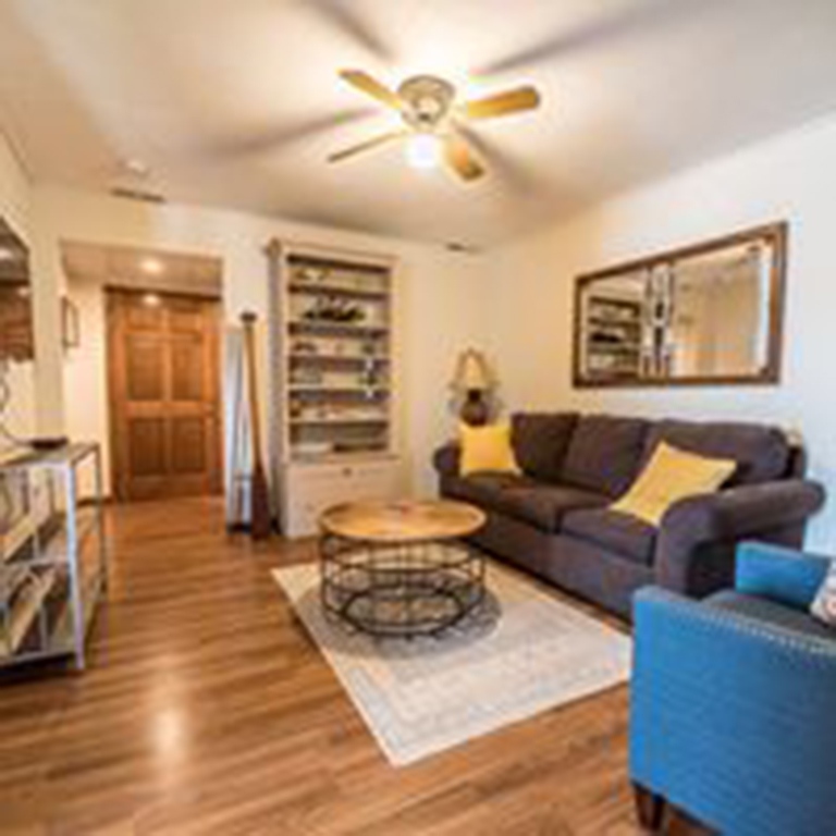 cropped living room with ceiling fan and couch