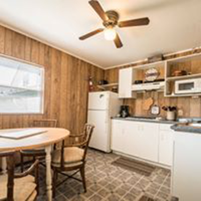 cropped bedroom with wooden walls and fridge