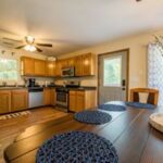 cropped kitchen with wooden cabinets and round rug