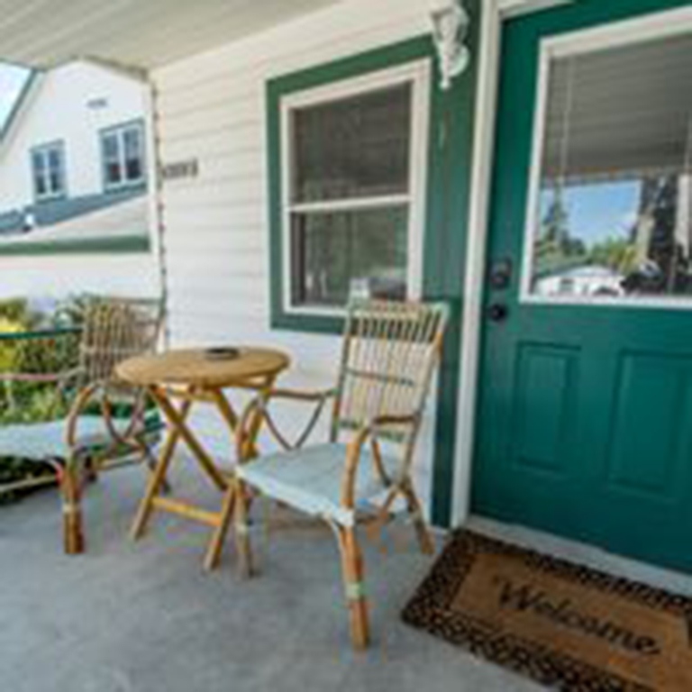 cropped patio with green door and table with chairs