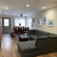 cropped living room with u-shaped couch and framed photos